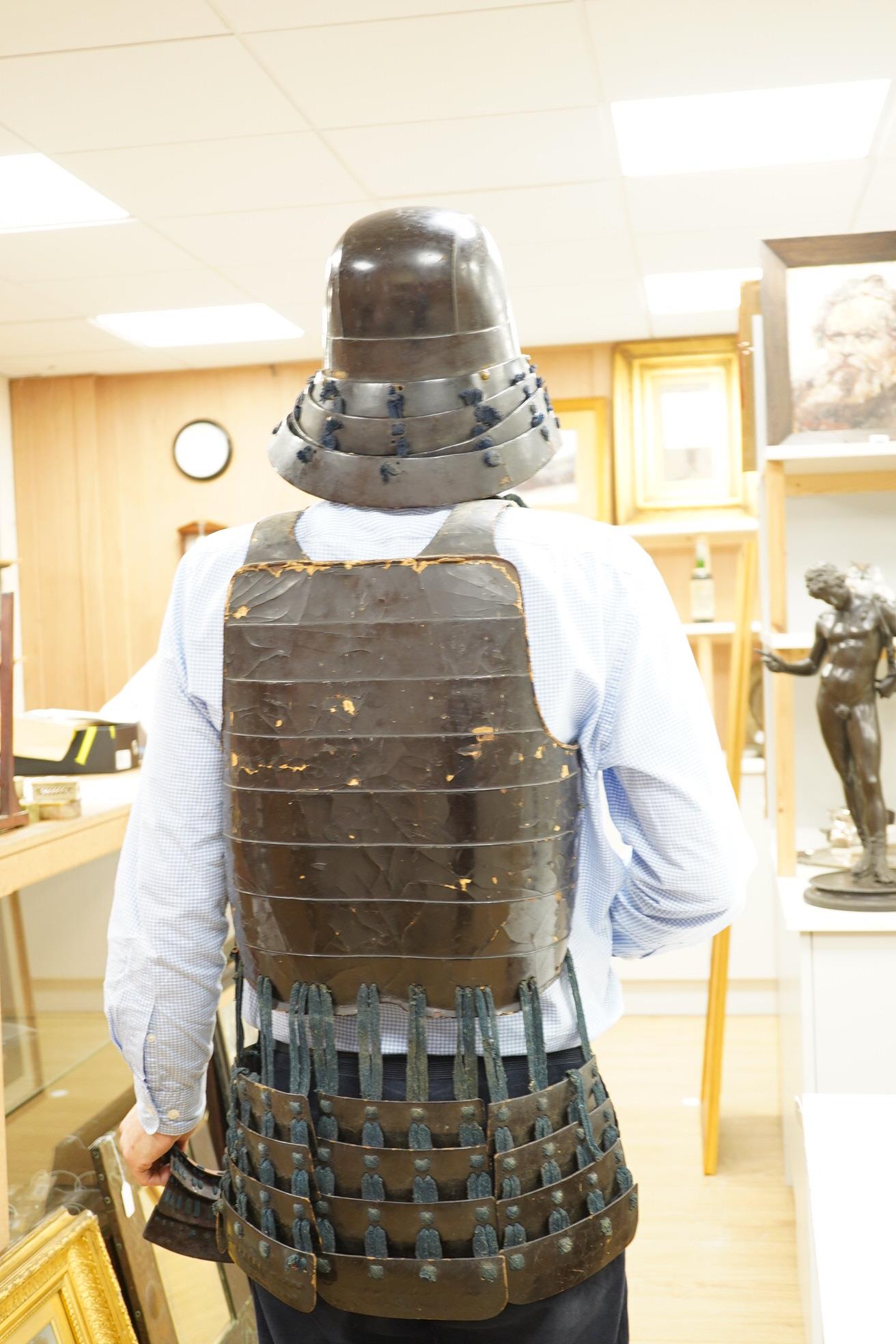 A Japanese armour, 19th century or earlier comprising; helmet Kabuto of five plates covered in black lacquer with 4-plate shikoro, also an iron lacquered mempo with three lames to throat and a do opening at side, embosse